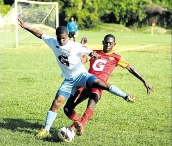 Cornwall College’s Alex McFarlane tackles Shane Haughton of Maldon High in their daCosta Cup Zone A game in Montego Bay yesterday. Cornwall won 6-0. (Photo: Paul Reid)