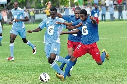 Kendon Anderson of St George’s College (second left) is double-teamed by two Clan Carthy players during their Manning Cup preliminary round match at Winchester Park on Saturday. Anderson scored four times in St George’s 15-0 victory. (Photo: Jermaine Barnaby)