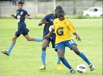 Okeem Dorman of Cedric Titus (right) tries to work his way past Dave Stone of Mannings during their ISSA/Gatorade/Digicel daCosta Cup quarter-final game at Drax Hall yesterday. Cedric Titus won 2-1. (Photo: Paul Reid)