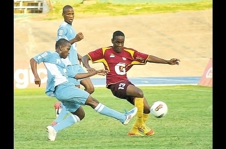 Cordel Benbow (left) shoots ahead of Andre Wilson of Wolmer’s (right) to score the opening goal for St George’s College during their ISSA/Digicel/Gatorade Manning Cup semi-final game at the National Stadium yesterday. St George’s won 2-0. (Photo: Garfield Robinson)