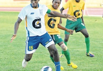 Rodney Whitter of STETHS (left) dribbles awaay from Grange Hill's Keva Kessna during their rural area Ben Francis KO schoolboy final at Montego Bay Sports Complex on Saturday. STETHS won the game 4-2 on penalties. (Photo: Paul Reid)