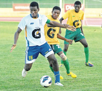 Rodney Whitter of STETHS (left) dribbles awaay from Grange Hill's Keva Kessna during their rural area Ben Francis KO schoolboy final at Montego Bay Sports Complex on Saturday. STETHS won the game 4-2 on penalties. (Photo: Paul Reid)