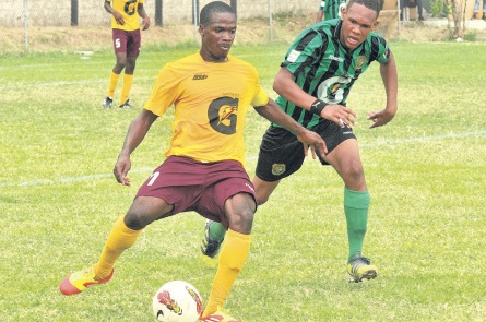 Spanish Town High’s captain Owen Walters (left) makes a pass under the close scrutiny of Calabar High’s Kevan Thompson in yesterday’s ISSA/Gatorade/Digicel Manning Cup Group H clash at the Constant Spring playfield. Spanish Town won 2-1. (Photo: Garfield Robinson)