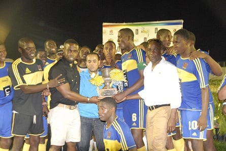 Representatives of the sponsors, Jermaine Brown of Wisynco (second left) Carlo Redwood of LIME and Garth Sommerville of Burger King (second right) hands over the ISSA/LIME daCosta Cup to Romario Thompson, captain of STETHS at the Montego Bay Sports Complex Saturday. (Photo: Paul Reid)