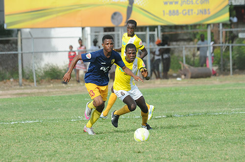 Romain Carthy (left) of STATHS being chased by Alton Lewis of Charlie Smith during their Flow/ISSA Group D Manning Cup game at the Anthony Spaulding Sports Complex. Charlie Smith won 3-0.